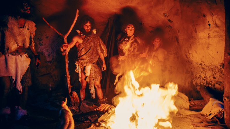 Humanos pré-históricos em volta de uma fogueira
