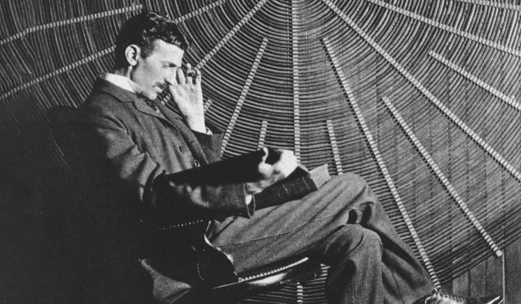 Nikola Tesla lê em frente a uma bobina