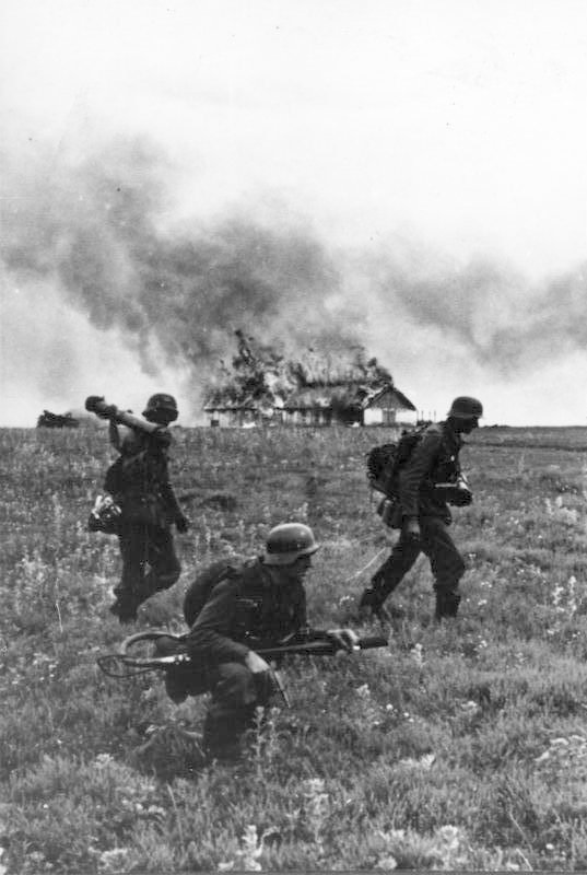 Três soldados da Divisão "Grande Alemanha" com lança-chamas em combate por uma vila